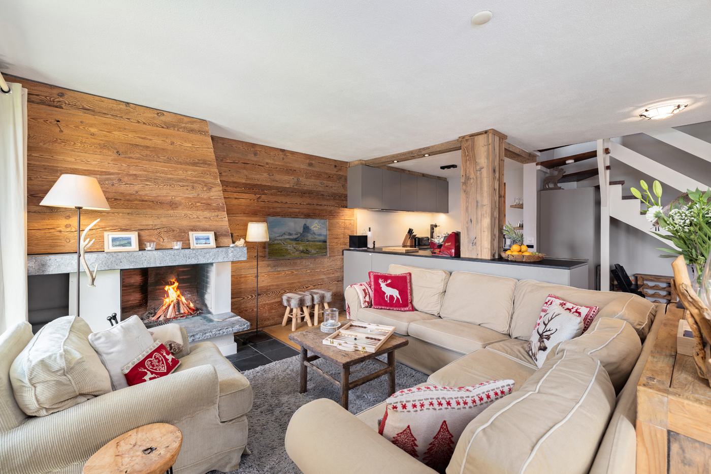Intérieur chaleureux d'un chalet à Crans-Montana avec cheminée et mobilier de standing